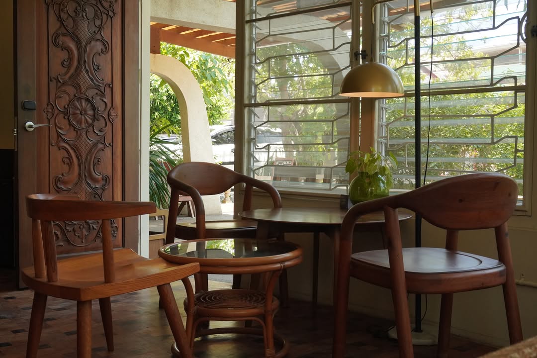 Cafe interior with ornate carved wooden door and pendant lamp