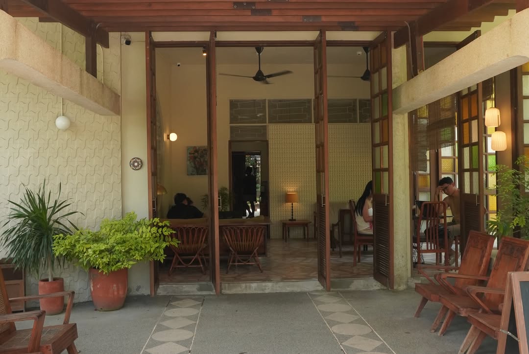 Cafe seen through glass doors with mid-century chairs and parquet floors